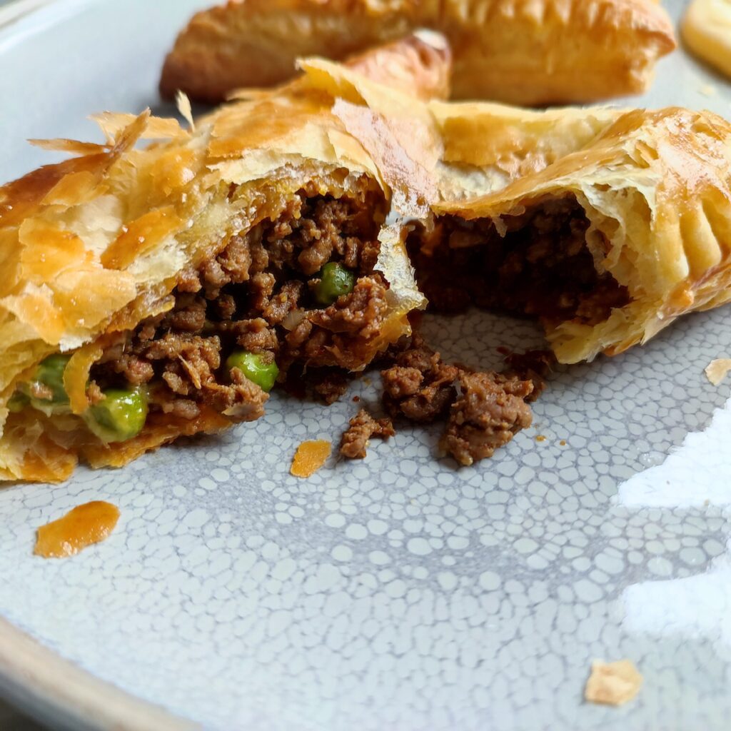 Tore Cheesy Keema Puff Pastry on a large gray plate