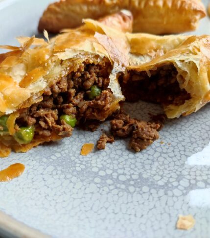 Tore Cheesy Keema Puff Pastry on a large gray plate