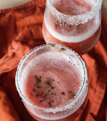 Frosé Punch in two wine glasses set on terracotta coloured cloth on a working surface