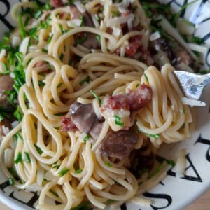 A plate Italian Carbonara with Mushrooms & Smoked Turkey with a small portion of it on a fork