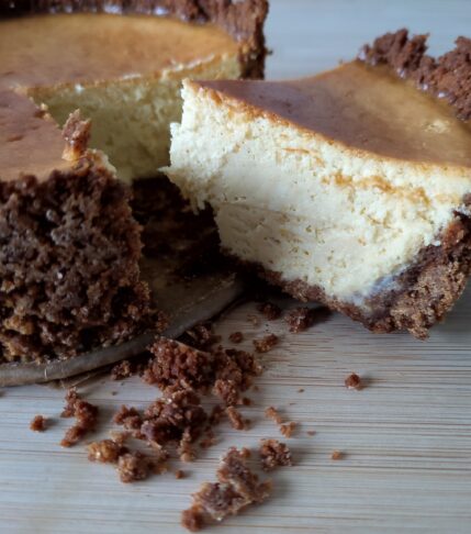 Rustic Airfryer Pumpkin Spiced Cheesecake with a slice cut and some cookie butter base crumbs on the side