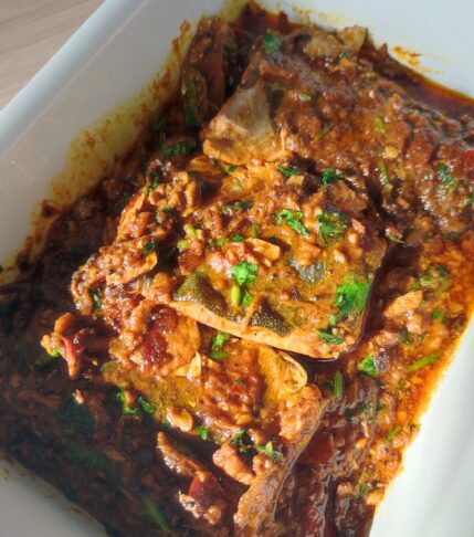 South Indian Fish Curry in a white coloured casserole dish on a working surface