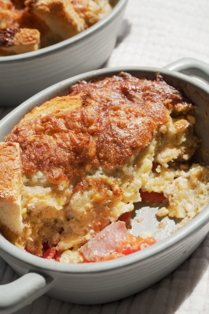 B roll 1: Breakfast Strata in two mini casserole dish and one is half eaten on cream coloured textured cloth side view