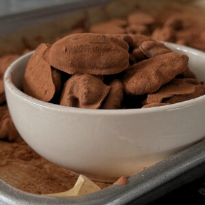 A full bowl of Pecan Truffles on a tray full of remaining Pecan Truffles